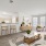 Spacious and well lit living room with wood flooring, large windows and open access to the kitchen